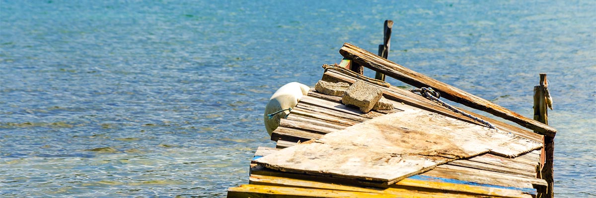 Storm damaged pier in clear blue water