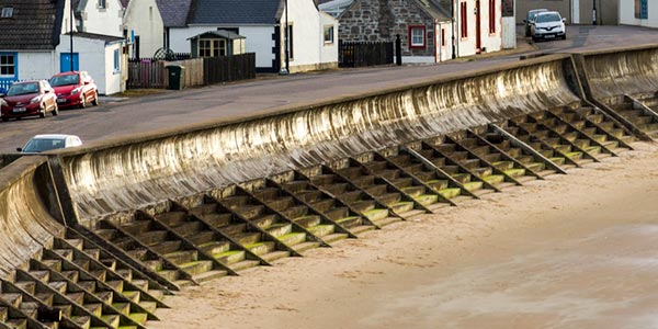 Large curved seawall protecting homes